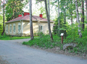 Keltainen puurakennus. jonka lähellä Aleksanteri II:n muistokivi sijaitsee.