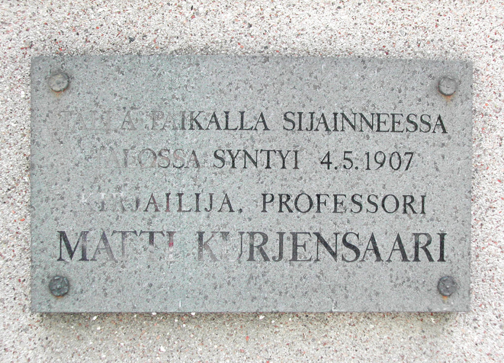 Muistolaatan teksti: Tällä paikalla sijainneessa talossa syntyi 4.5.1907 kirjailija, professori Matti Kurjensaari.