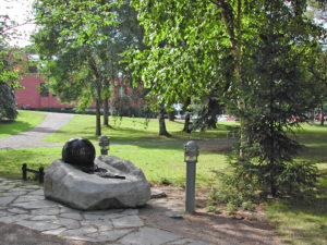 Puistossa oleva kivi, jonka päällä on vedessä pyörivä graniittipallo.